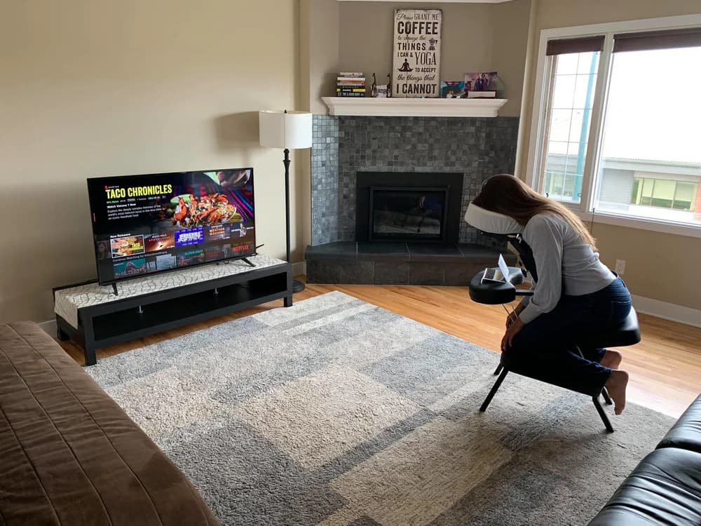 Patient using a face down chair and mirror to watch TV at home